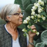 Close up portrait of happy older woman standing outside in summer